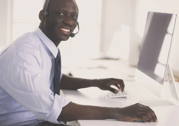 Африканський американський бізнесмен на навушниках працює над ноутбуком — стокове фото