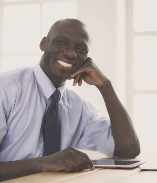 Afrykański amerykański biznesmen na słuchawkach pracuje na swoim laptopie — Zdjęcie stockowe