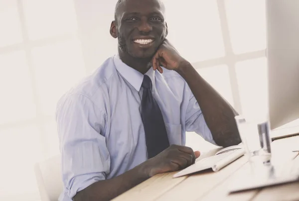 Empresário afro-americano no fone de ouvido trabalhando em seu laptop — Fotografia de Stock