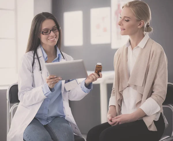 Doctor y paciente discutiendo algo mientras están sentados en la mesa. Concepto de medicina y salud — Foto de Stock