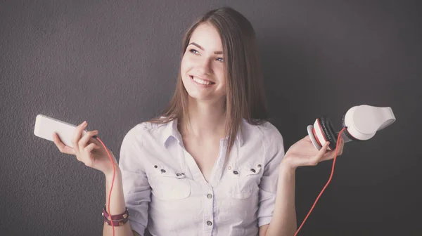 Chica sonriente con auriculares aislados sobre fondo gris —  Fotos de Stock