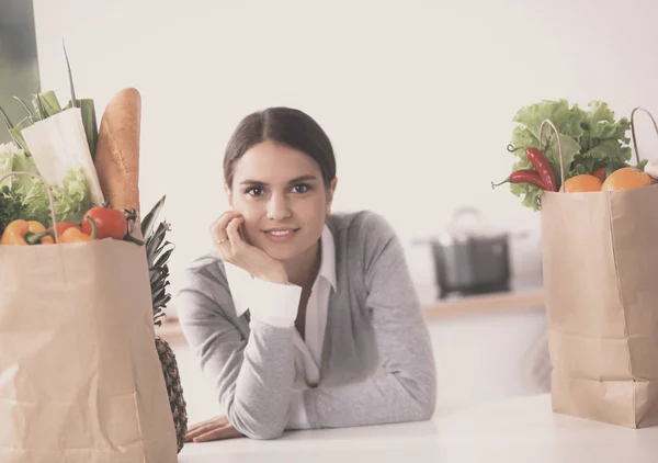 Retrato de uma mulher sorrindo cozinhar em sua cozinha sentado — Fotografia de Stock