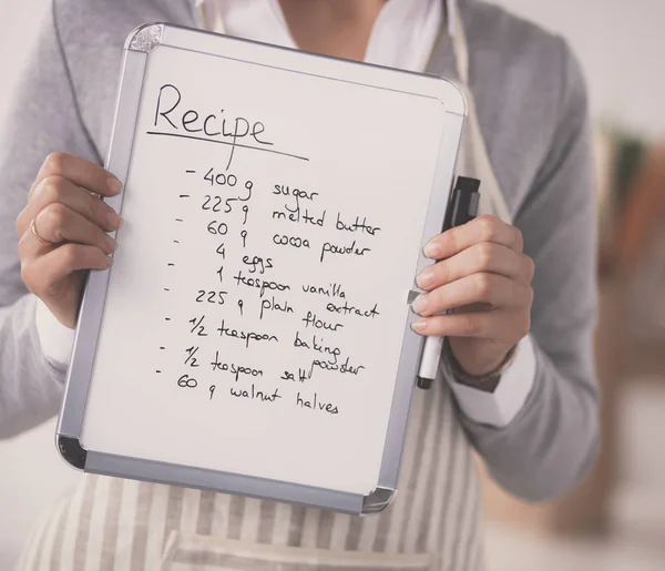 Woman in the kitchen at home, standing near desk with folder — Stock Photo, Image