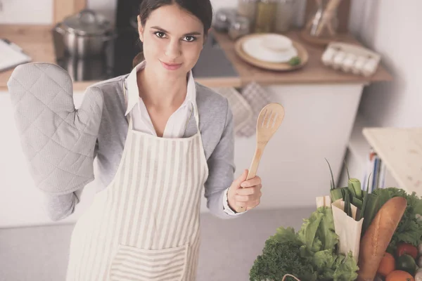 Vrouw maken van gezonde voeding staande glimlachend in keuken — Stockfoto