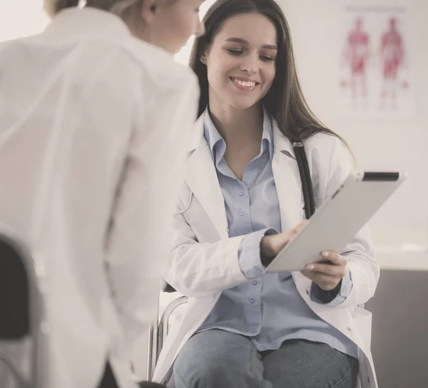 Doktorn och patienten diskuterar något när de sitter vid bordet. Medicin och hälsovård — Stockfoto