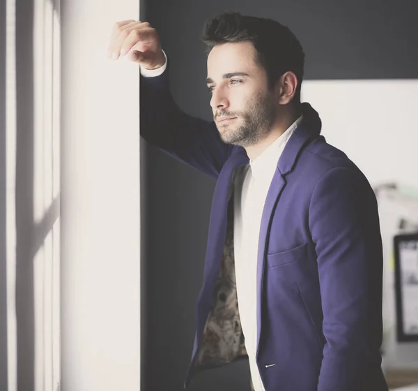 Business man in suit talking on phone and looking away near the window. — Stock Photo, Image