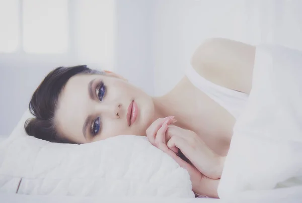 Fiatal gyönyörű nő fekszik az ágyban. — Stock Fotó