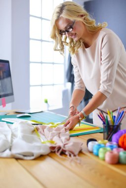 Moda tasarımcısı kadın stüdyoda tasarımları üzerinde çalışıyor..