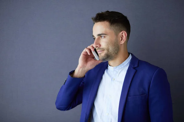 Joven empresario sentado aislado sobre fondo gris. —  Fotos de Stock