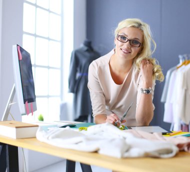 Moda tasarımcısı kadın stüdyoda tasarımları üzerinde çalışıyor..