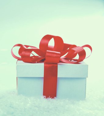 Kırmızı kurdeleli beyaz hediye kutusu.