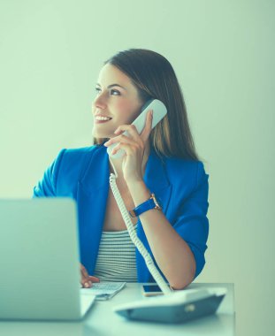 Telefon bir dizüstü bilgisayar önünde genç kadın portre