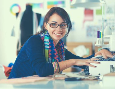 Çalışırken dikiş diken genç bir kadın.