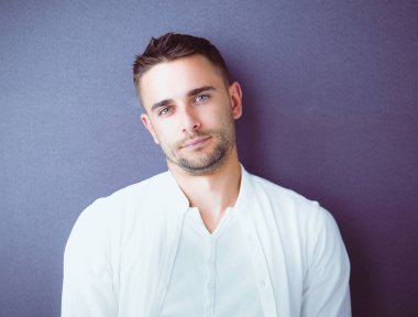 Genç iş adamı beyaz arka planda tek başına duruyor.