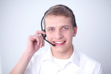 Gri arka plan üzerinde oturan gülümseyen genç adam portresi. Genç adam portresi