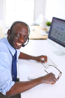 Kulaklıklı Afro-Amerikan işadamı laptopuyla çalışıyor.