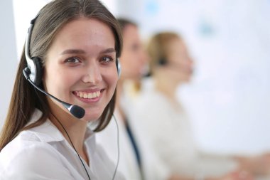 Ofisinde kulaklık ve bilgisayarla gülümseyen iş kadını ya da yardım hattı operatörü