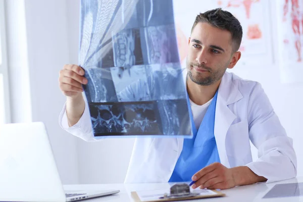 Médico bonito está conversando com jovem paciente do sexo feminino e fazendo anotações enquanto está sentado em seu escritório. — Fotografia de Stock