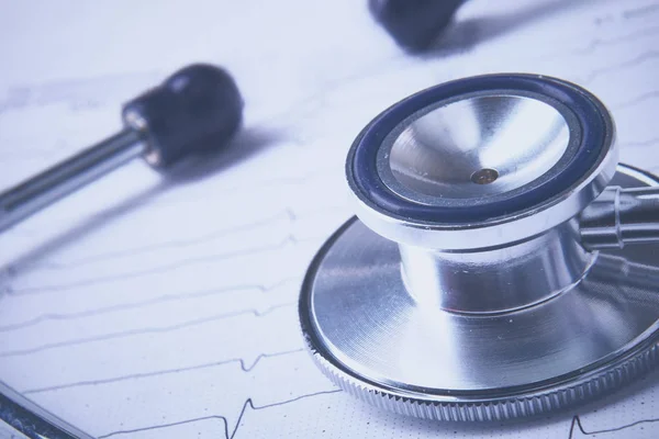 Stethoscoop op elektrocardiogram liggend aan het bureau — Stockfoto