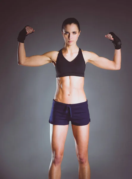Musculosa joven posando en ropa deportiva sobre fondo negro . — Foto de Stock