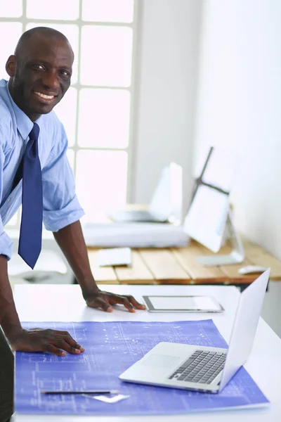 Architecte afro-américain travaillant avec l'ordinateur et les plans dans le bureau — Photo