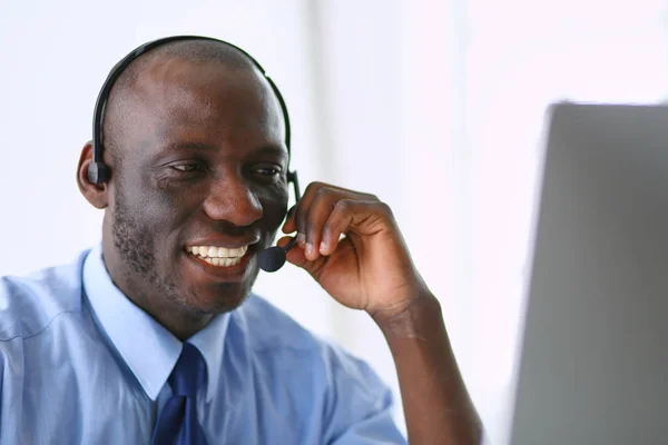 Homme d'affaires afro-américain sur casque de travail sur son ordinateur portable — Photo