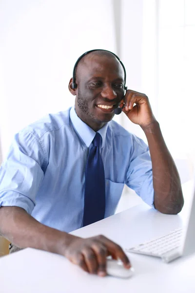 African american businessman on headset working on his laptop — Stock Photo, Image