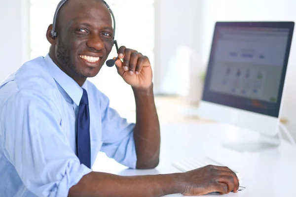 Homme d'affaires afro-américain sur casque de travail sur son ordinateur portable — Photo