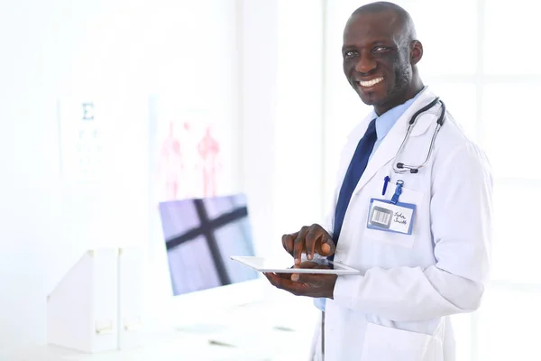 Trabajador médico negro masculino con tableta de pie en el hospital — Foto de Stock