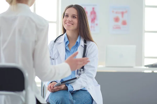 Médico e paciente discutindo algo enquanto se senta na mesa. Conceito de medicina e cuidados de saúde — Fotografia de Stock