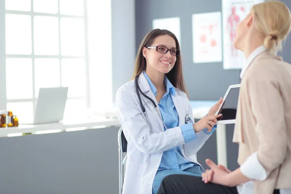 Docteur et patient discutant de quelque chose assis à la table. Médecine et soins de santé concept — Photo