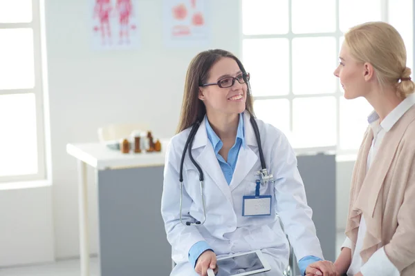 Doktorn och patienten diskuterar något när de sitter vid bordet. Medicin och hälsovård — Stockfoto