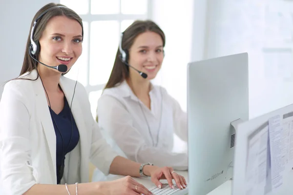 Smiling businesswoman or helpline operator with headset and computer at office — Stock Photo, Image