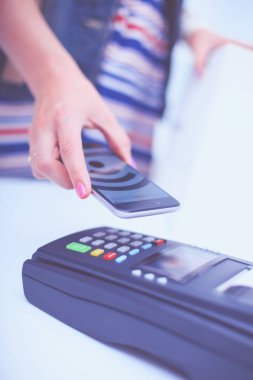 Müşteri ile smartphone Nfc teknolojisi kullanılarak dükkanda ödüyor. NFC teknolojisi. Müşteri ödeme.