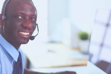 Kulaklıklı Afro-Amerikan işadamı laptopuyla çalışıyor.