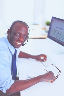 Kulaklıklı Afro-Amerikan işadamı laptopuyla çalışıyor.