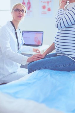 Hastanede doktorla gülümseyen güzel bir hamile kadın.