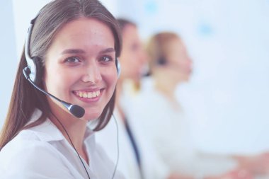 Ofisinde kulaklık ve bilgisayarla gülümseyen iş kadını ya da yardım hattı operatörü