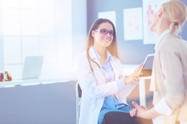 Doktor ve hasta masada otururken bir şey tartışıyorlar. İlaç ve sağlık hizmetleri kavramı