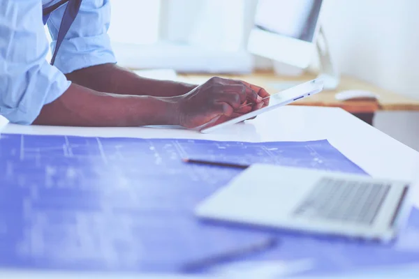 Arquitecto afroamericano trabajando con computadoras y planos en la oficina —  Fotos de Stock