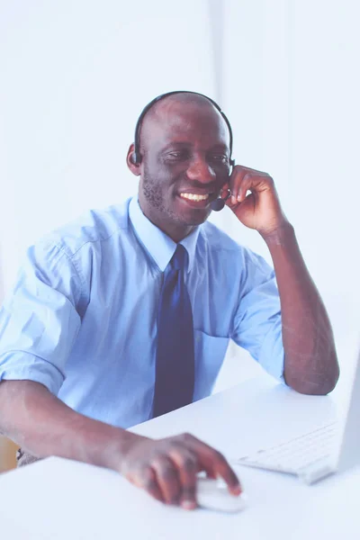 Kulaklıklı Afro-Amerikan işadamı laptopuyla çalışıyor. — Stok fotoğraf