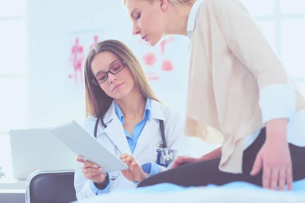 Doktorn och patienten diskuterar något när de sitter vid bordet. Medicin och hälsovård — Stockfoto