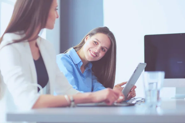 Two female colleagues in office sitting on the desk — Stock Photo, Image
