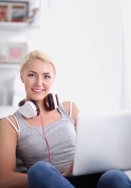 Evdeki genç ve güzel kadın kanepede oturup müzik dinliyor.