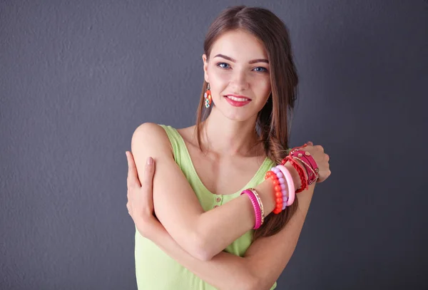 Portret van een jonge glimlachende vrouw op een grijze achtergrond — Stockfoto