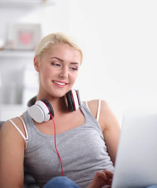 Młoda piękna kobieta w domu siedzi na kanapie i słucha muzyki — Zdjęcie stockowe