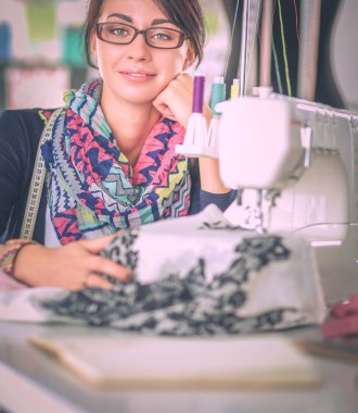 Çalışırken dikiş diken genç bir kadın.