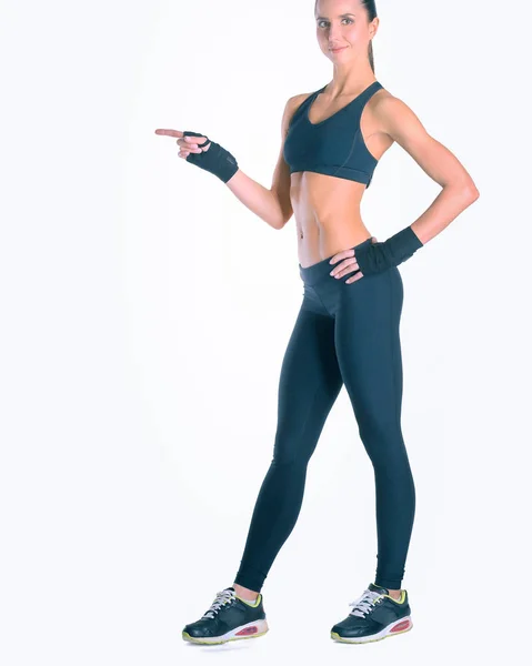 Muskulöse junge Frau posiert in Sportkleidung vor weißem Hintergrund — Stockfoto