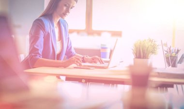 Masada dizüstü bilgisayarı olan kadın.