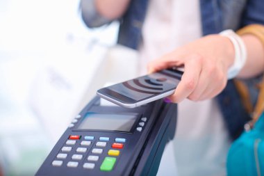 Müşteri ile smartphone Nfc teknolojisi kullanılarak dükkanda ödüyor. NFC teknolojisi. Müşteri ödeme